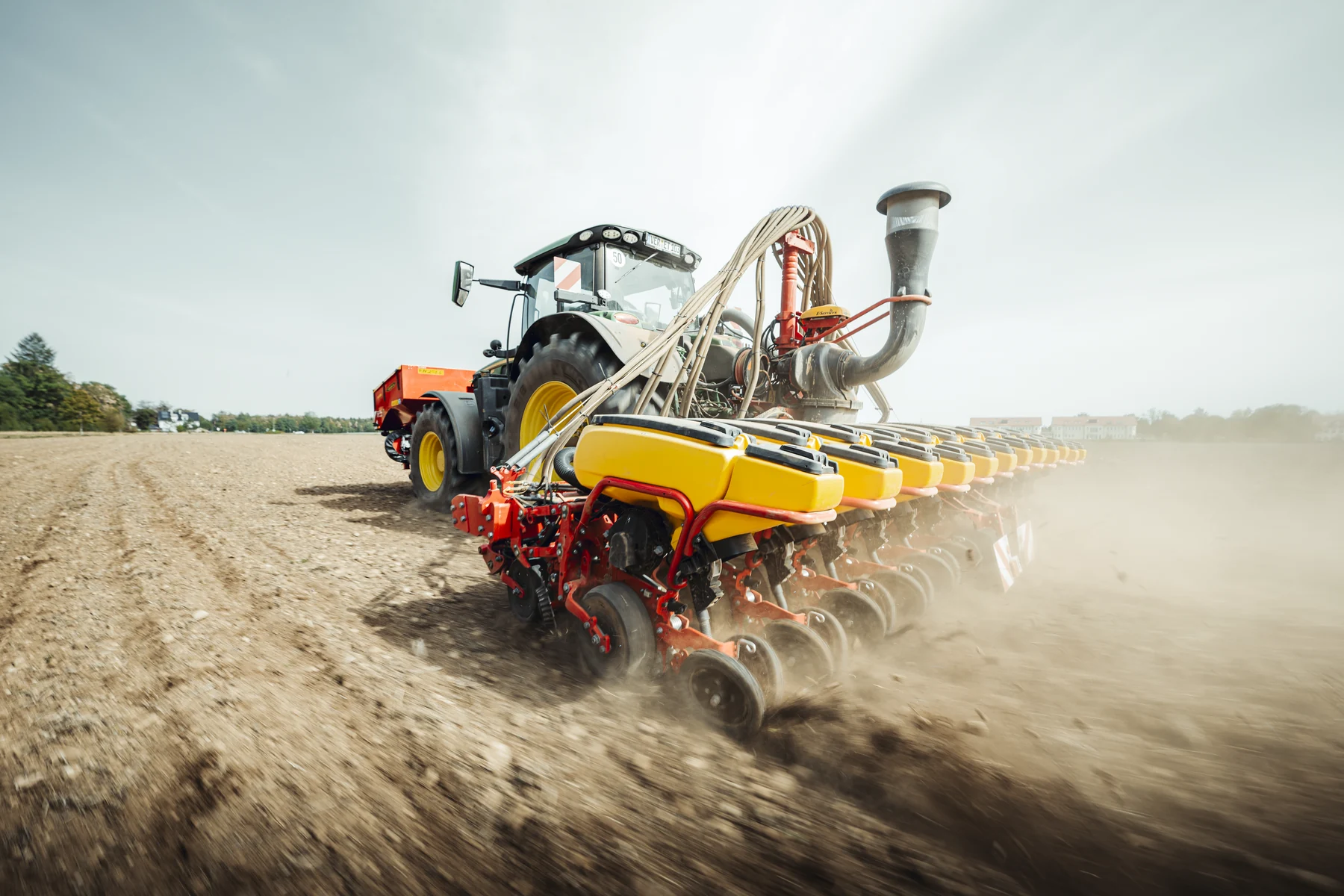 Traktor mit zwölfreihiger Sämaschine bei der Rapssaat