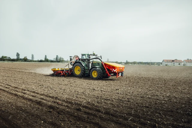 Blick auf Traktor und Sämaschine beim Feldeinsatz.