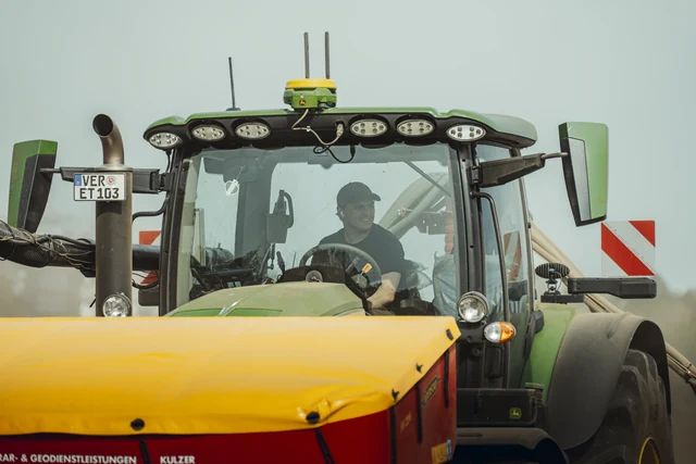 Marco Kulzer am Steuer des Traktors bei der Feldarbeit.