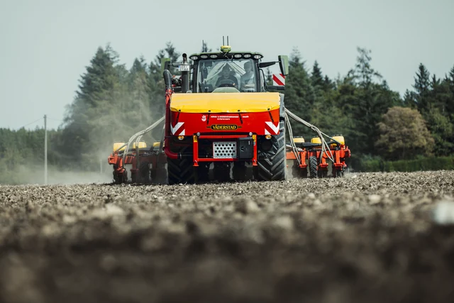Traktor mit angebauter Sätechnik auf dem Feld.
